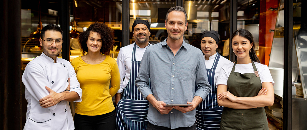 Restaurant owner and employees stand together as a team