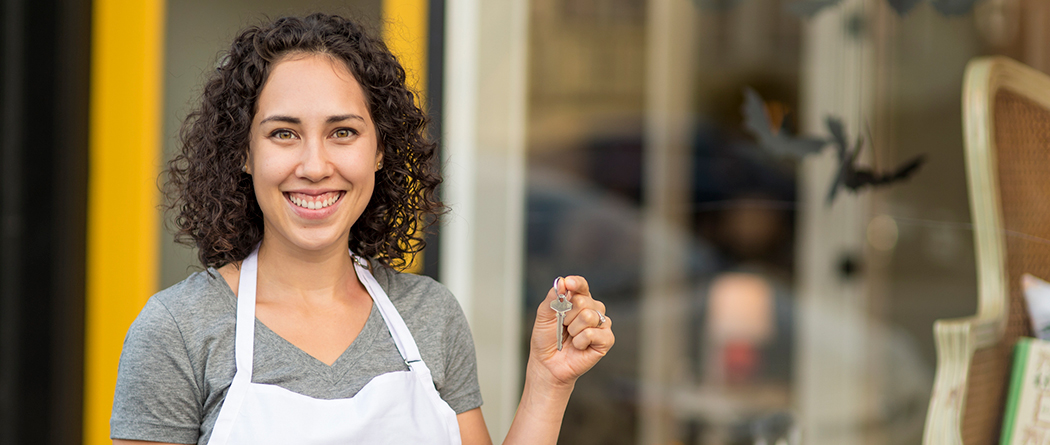 Entrepreneur celebrates with key in hand at her new business location