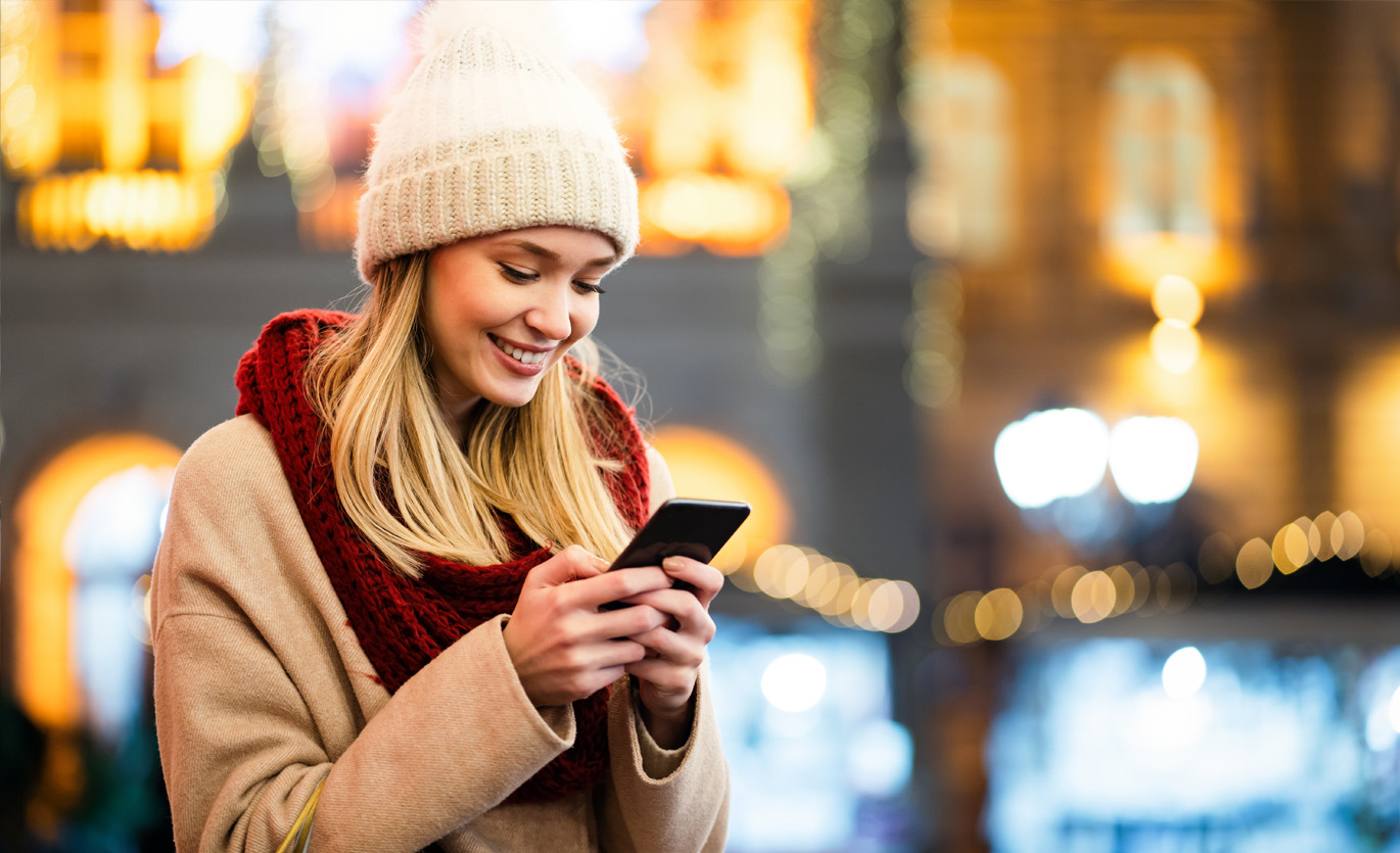 woman dressed for cold weather using phone
