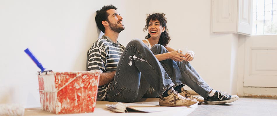 A young couple painting their house