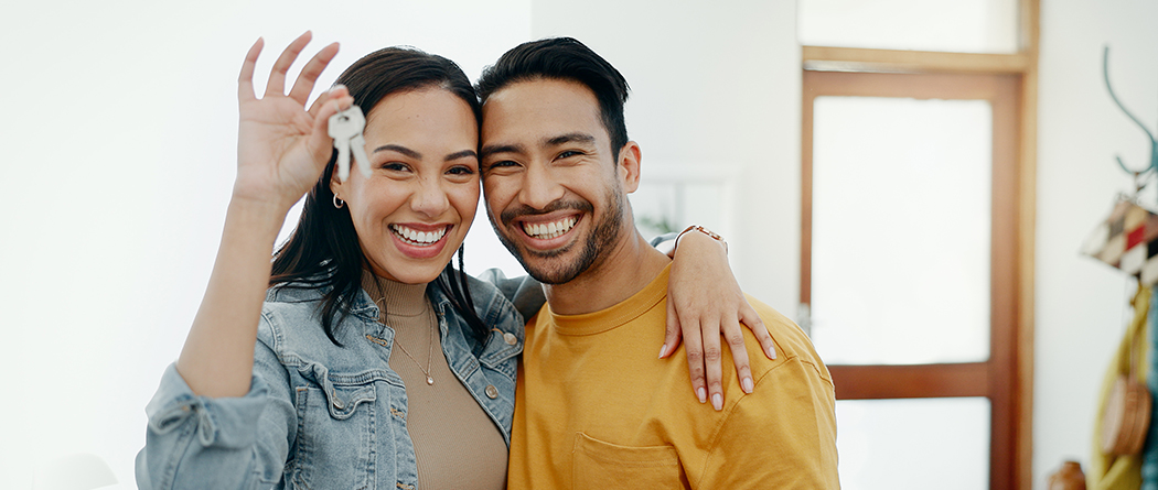 Couple happily holding keys to new home